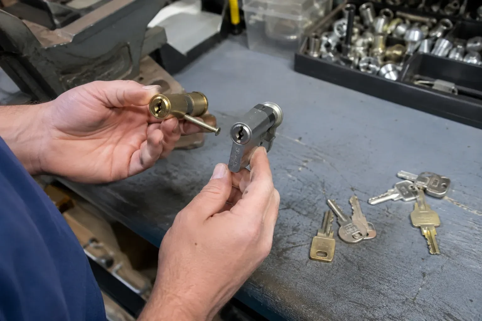 Hands comparing detached lock cylinders beside loose keys on a workbench. — Broken Key Extraction, Barrie